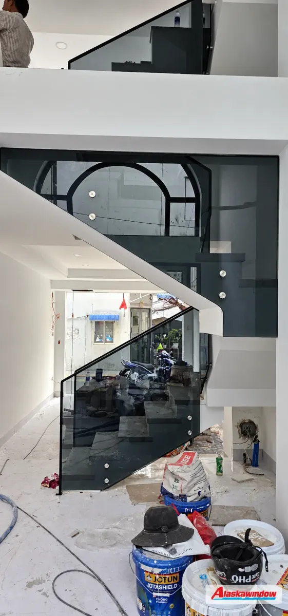 Các vế cầu thang kính nối tiếp nhau trong nhà đang thi công hoàn thiện