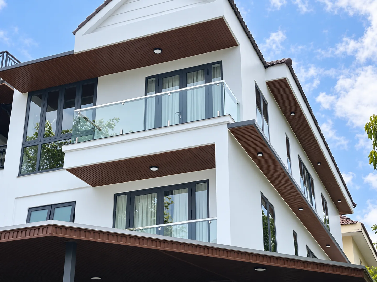 Cửa ban công và lan can kính trên mặt đứng biệt thự anh Thành Jamona