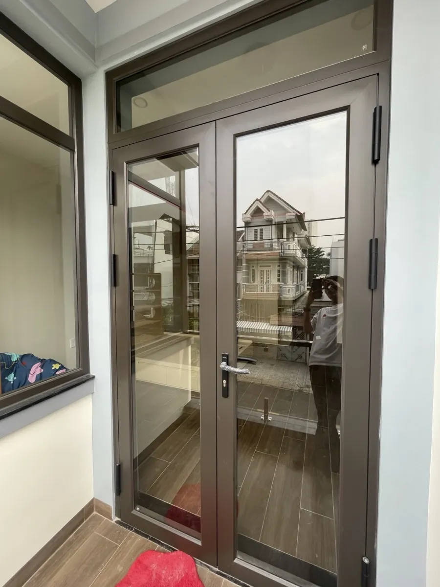 Cửa ban công hai cánh nhôm Deluxe Casa có ô kính trên cạnh mảng kính bên
