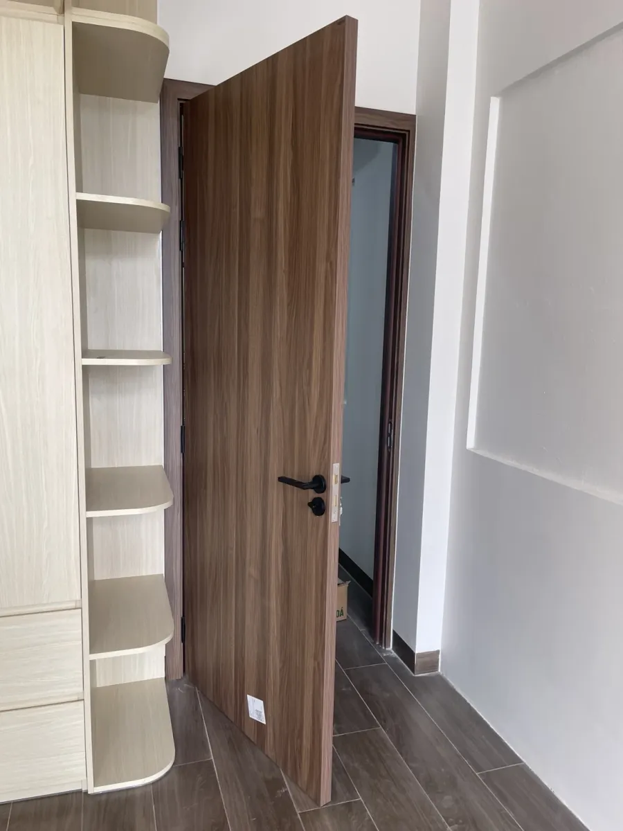 Cửa nội thất bề mặt vân gỗ đang mở cạnh tủ tại công trình Quận 9