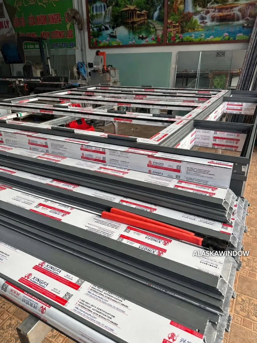 Khung và cánh nhôm Xingfa hệ 100 được tập kết trên bàn tại xưởng