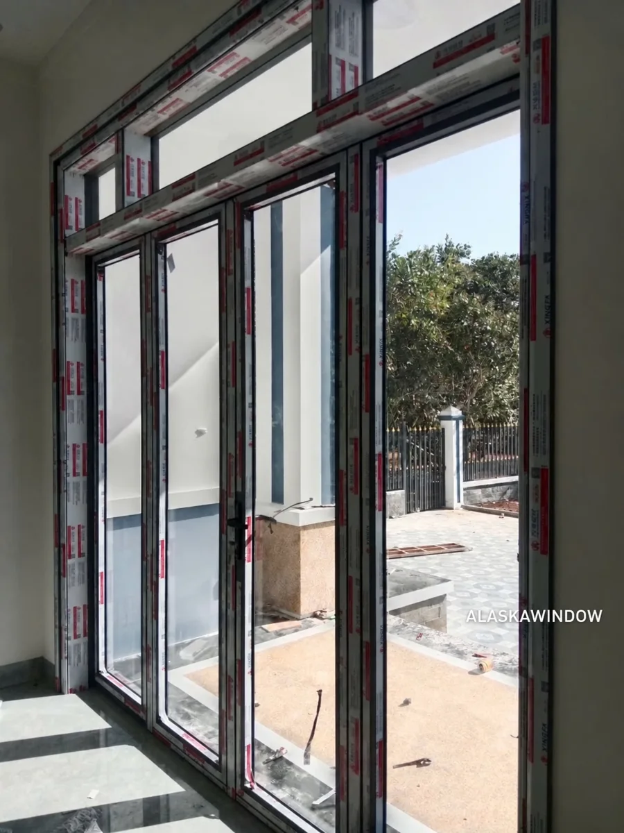 Hệ cửa nhôm kính nhiều ô và ô kính phía trên nhìn từ trong nhà tại Thủ Đức