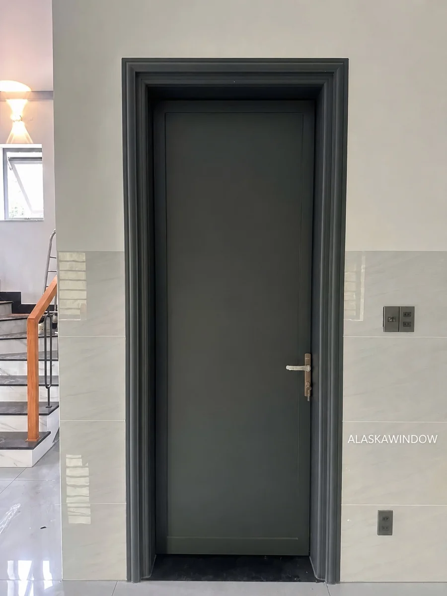 Cửa phòng nhôm tấm màu xám đậm đã tháo màng, phào chỉ đồng màu