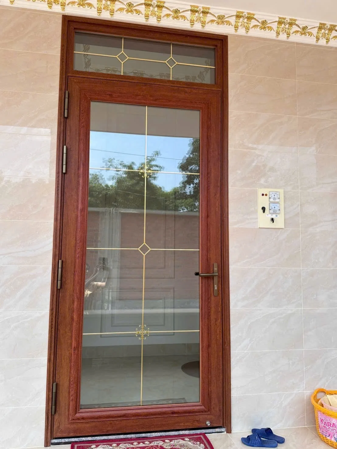 Cửa đi một cánh màu vân gỗ kết hợp kính hoa văn và ô kính phía trên